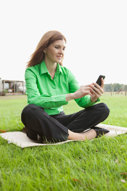 young woman using mobile phone outdoors - Foto, imagen