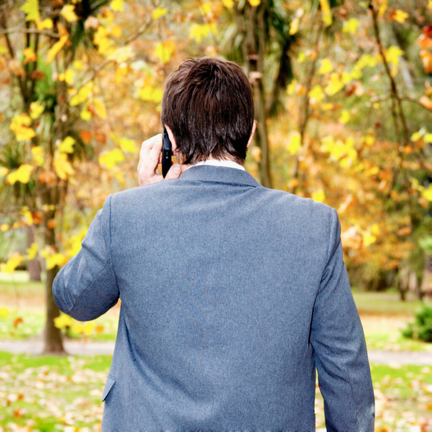 man in a jacket and a black coat walks in the autumn park - Photo, image
