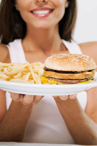 close-up of a woman holding a burger and a hamburger - Фото, зображення