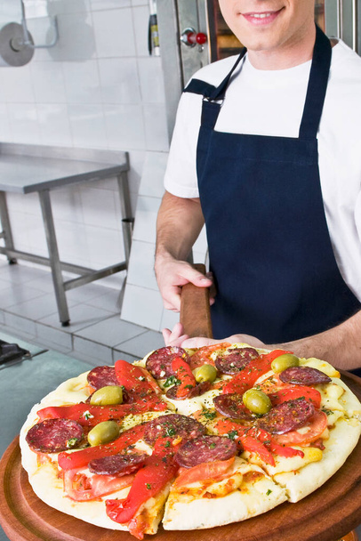 chef with pizza in the kitchen - Zdjęcie, obraz