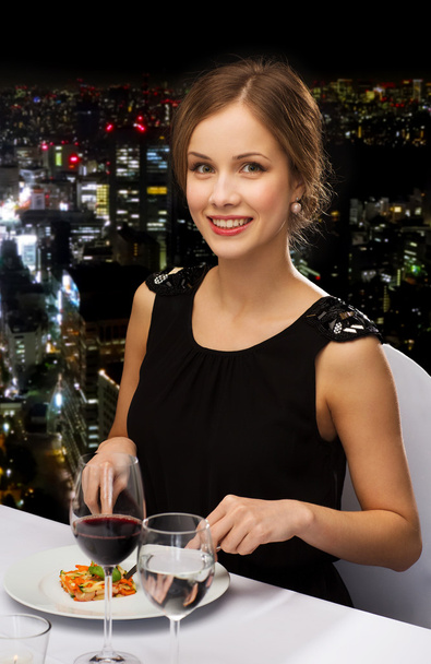 smiling young woman eating main course - Fotó, kép