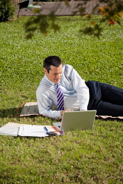 businessman sitting on grass and reading a book - Foto, Imagem