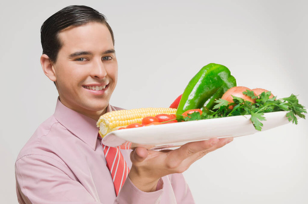 young man with vegetables in his hands - Foto, Imagem