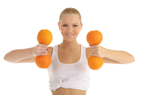 Woman engaged in fitness dumbbells of oranges - Photo, Image