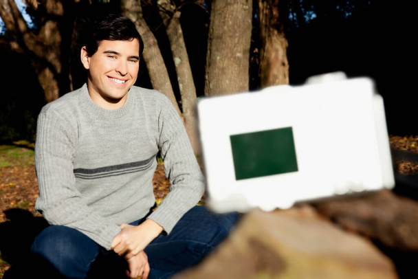 young man with a laptop in the park - Foto, Imagen