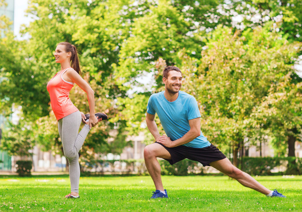 smiling couple stretching outdoors - Фото, зображення