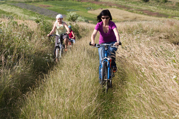 Familia montando en bicicleta en el prado
 - Foto, imagen