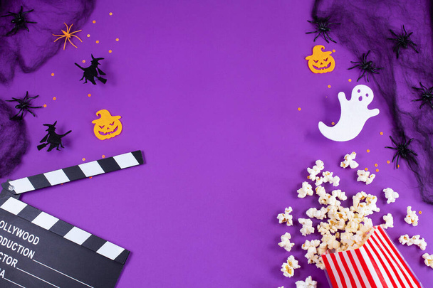 Ταινία Clapper σκάφους σε ιστούς αράχνης, αράχνες, φάντασμα, τα μάτια σε μωβ Lilac φόντο. - Φωτογραφία, εικόνα