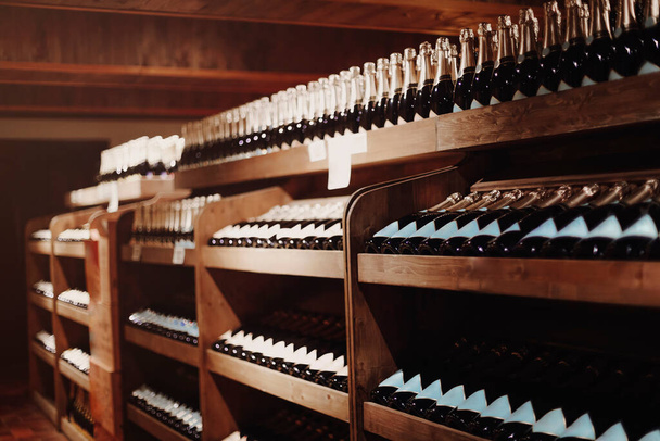Wine bottles on the shelves in the rack. Backgraund wine shop - Photo, Image