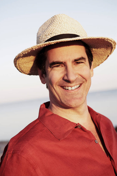 portrait of a happy young man in a hat on the beach - Photo, Image