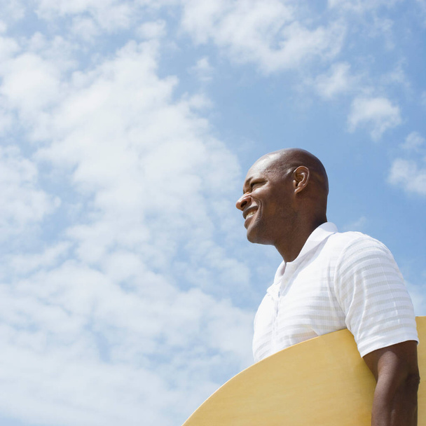 portrait of a young african american man with a white shirt and a blue sky - Foto, Imagem
