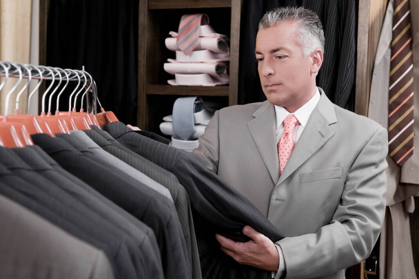 man choosing clothes in shop - 写真・画像