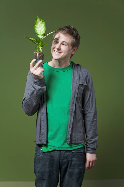young man holding a green plant - Fotografie, Obrázek