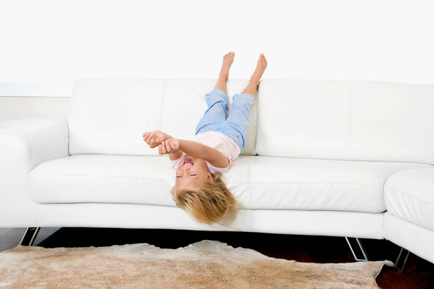 young woman lying on sofa and looking at camera - Foto, Bild
