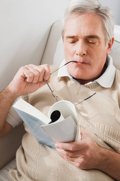 senior man reading newspaper at home - Фото, изображение
