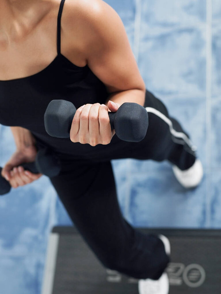 young woman doing exercises with dumbbells in the gym - Photo, image