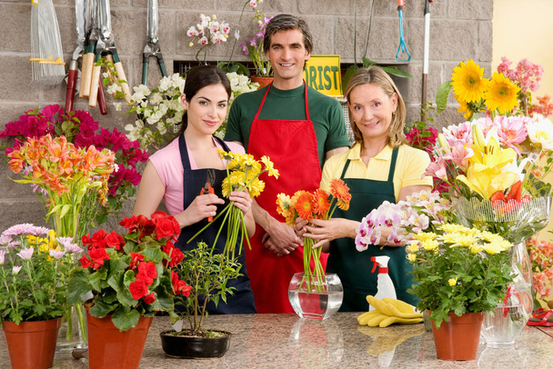 young beautiful florist and assistant working in a flower shop - Valokuva, kuva