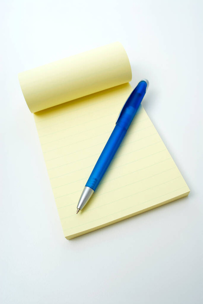 white paper with a pencil and a pen on a blue background - Photo, image