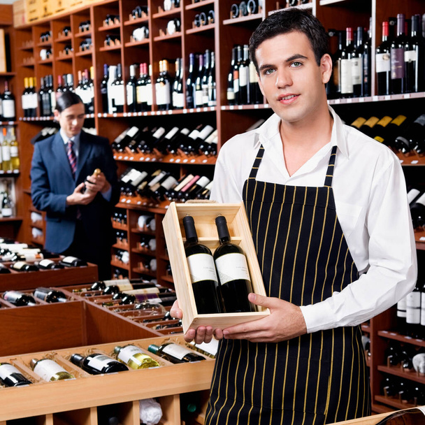 young man holding wine bottles in the bar - Photo, Image