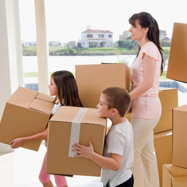 happy family with boxes in new home - Zdjęcie, obraz