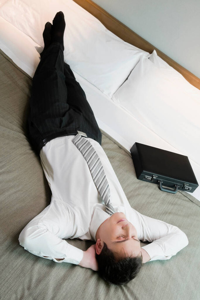 young woman lying on bed and working on laptop - Photo, Image