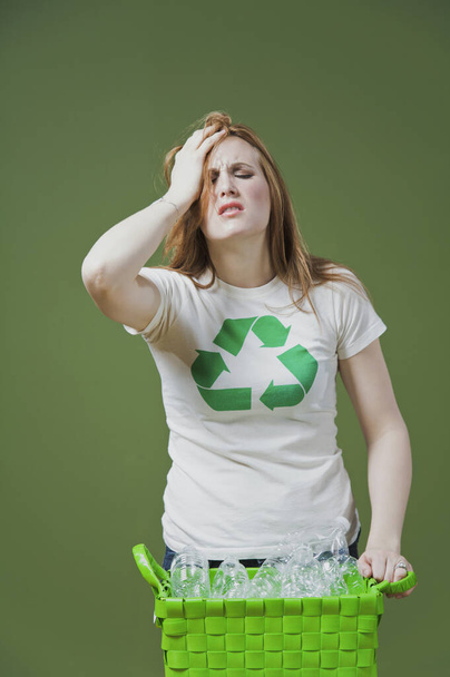 young woman with recycle sign on green background - Foto, Bild