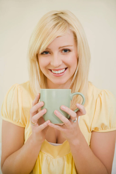 beautiful young woman with cup of tea on white background - Foto, afbeelding