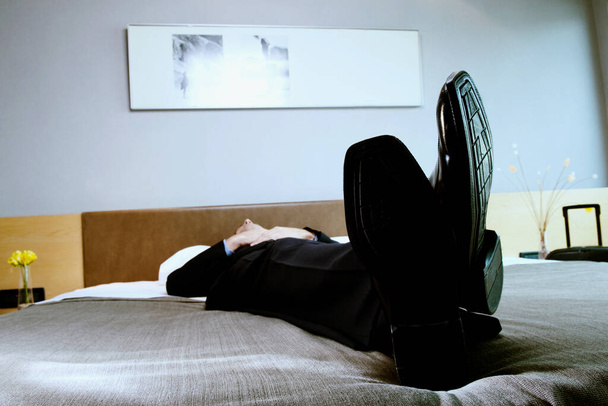 černobílá fotografie muže v obleku a křesle v pokoji - Fotografie, Obrázek