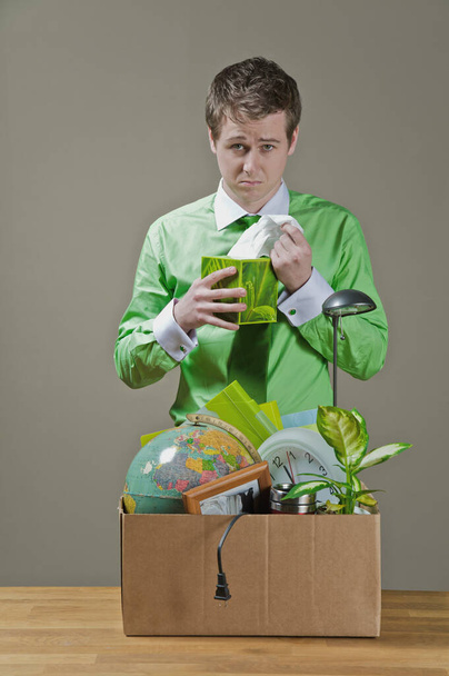 young man with a green bag of a plant in his hands - Фото, зображення