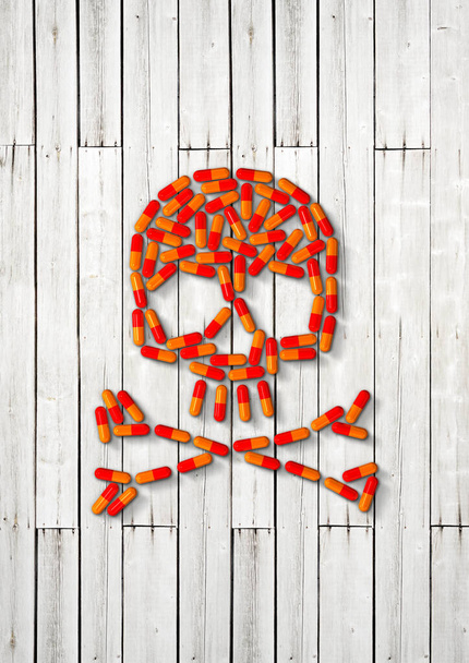 Skull made of orange capsule pills isolated on white wooden background. 3D illustration - Zdjęcie, obraz