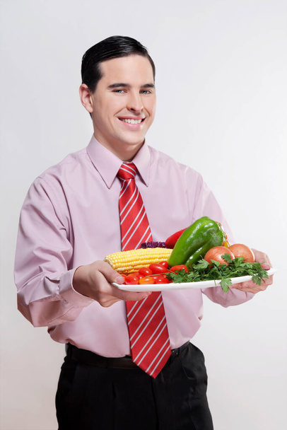 fiatal férfi eszik egy szendvicset egy piros tányérral - Fotó, kép