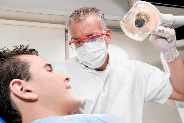 dentist examining patient in dental clinic - Fotografie, Obrázek