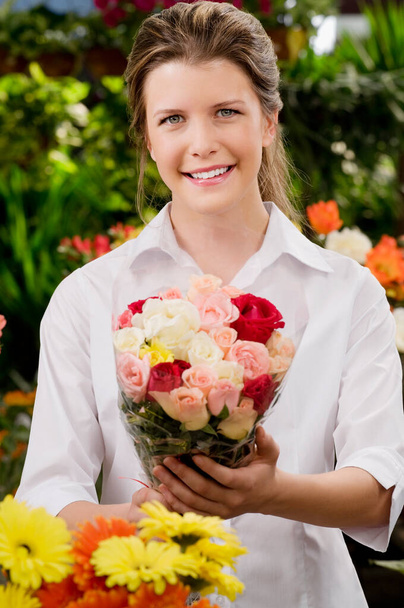 beautiful young woman with bouquet of flowers in hands - Fotografie, Obrázek