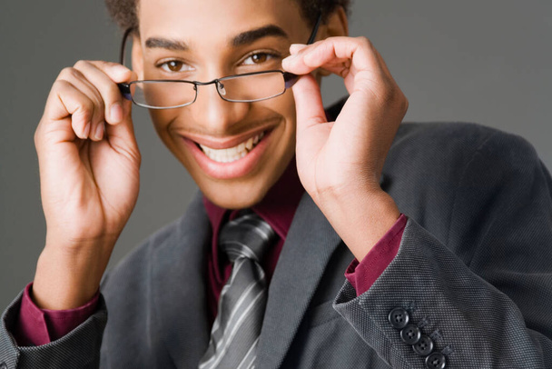 retrato de um jovem empresário com óculos em um fundo cinza - Foto, Imagem