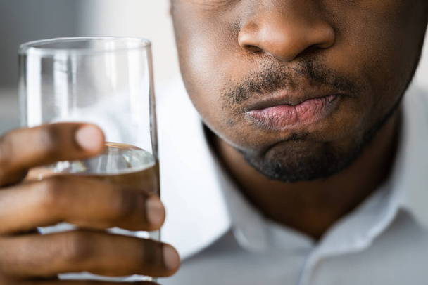 Boca de agua gárgara y enjuague. Hombre afroamericano con halitosis - Foto, imagen