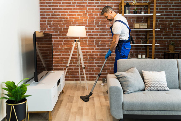 Man In Uniform Vacuuming House Floor. Cleaning Home - Photo, Image