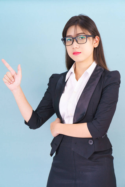 Asian business woman in suit with finger pointing up on blue background - Fotografie, Obrázek