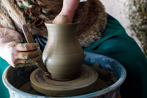 work on a potter's wheel. making a water jug. the moment of finishing work - Photo, Image
