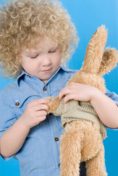 little boy with a toy on the blue background - Valokuva, kuva