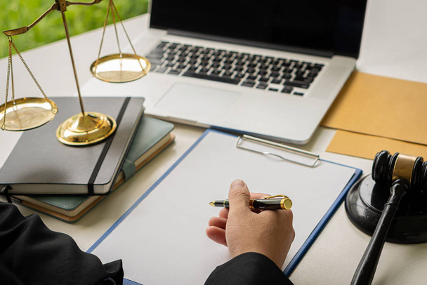 Attorney's Office Judge with hammer and scales with laptop on desk, businessman in suit or lawyer working on paperwork. Law, Guidance and Justice Concepts - 写真・画像