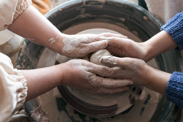 le mani dell'allenatore guidano il principiante. creazione di prodotti di argilla di prova. corsi di ceramica per principianti. - Foto, immagini