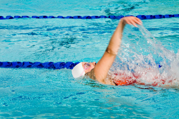 Perfil lateral de una joven nadando en una piscina - Foto, Imagen