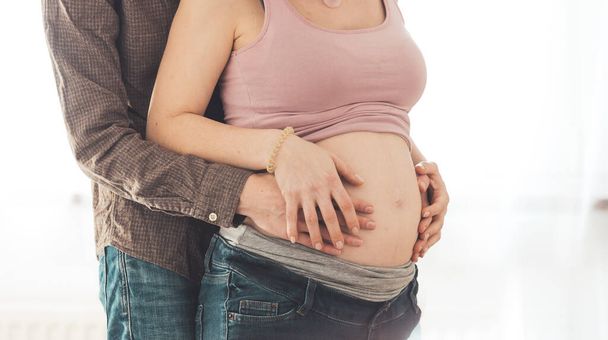Acercamiento de la madre y el padre embarazadas, abrazando la barriga, Caucásico - Foto, Imagen