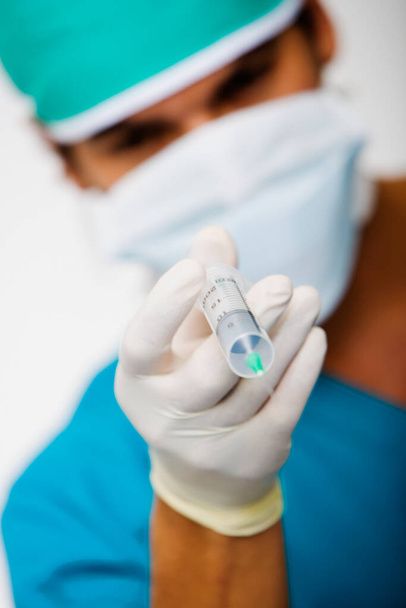 Close-up of a male surgeon holding a syringe - Foto, Bild