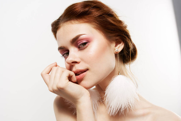 Frau mit nackten Schultern in flauschigen Ohrringen Schmuck Glamor helles Make-up - Foto, Bild