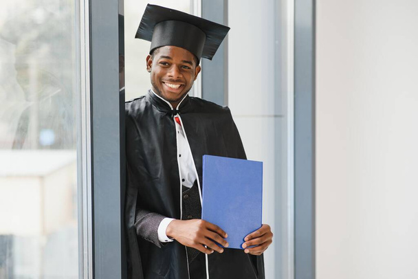 wesoły afrykański mężczyzna absolwent posiadający dyplom - Zdjęcie, obraz
