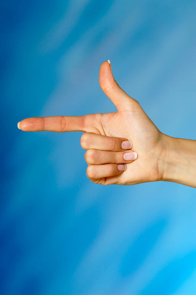 hand of woman pointing finger up on blue background - Foto, Bild