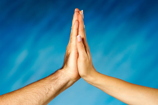 hands of a man and woman praying on blue background - Foto, imagen