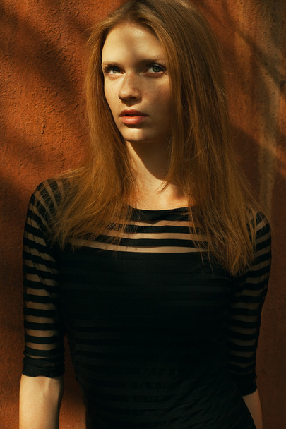 Fashion portrait of a young beautiful red-haired girl wearing tr - Photo, Image