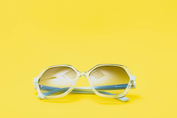 yellow sunglasses on yellow background - Фото, изображение